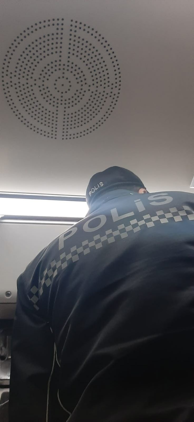 a police officer sitting in front of a laptop computer