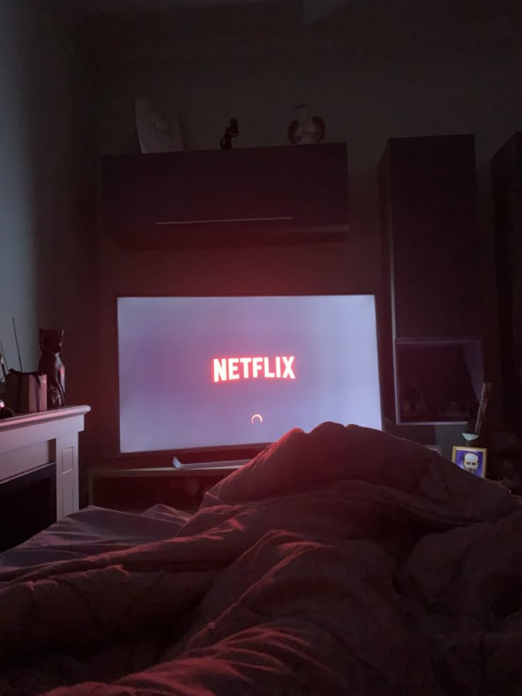 a television sitting on top of a bed in a dark room