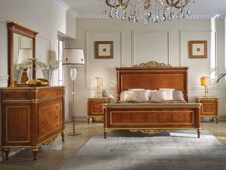 a large bed sitting in the middle of a bedroom next to a chandelier