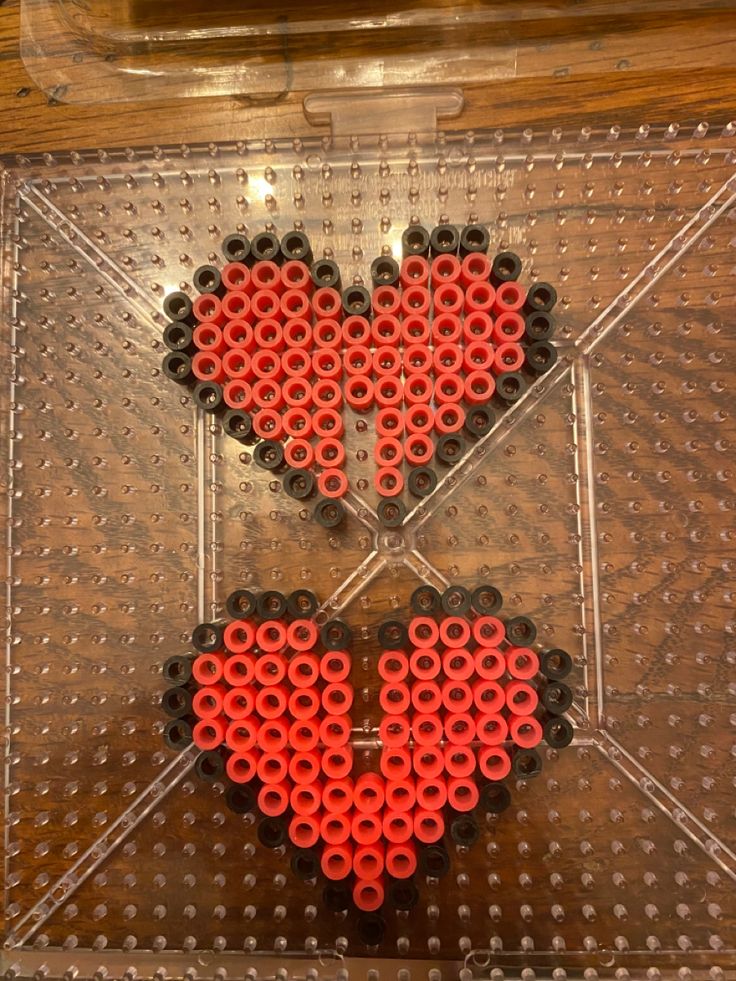 two hearts made out of legos sitting on top of a plastic tray next to each other