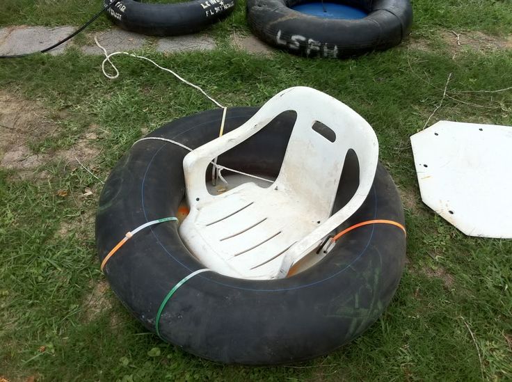 an inflatable boat is sitting on the grass next to some other boats and floats