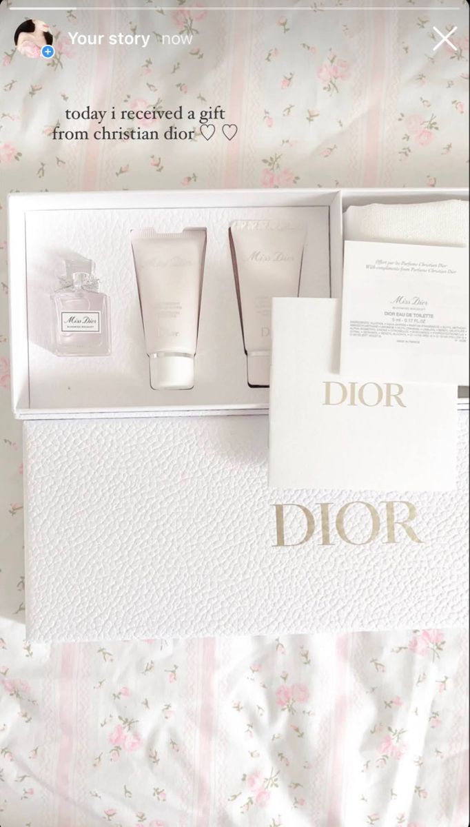 the contents of a dior gift set are displayed in a white box on a bed