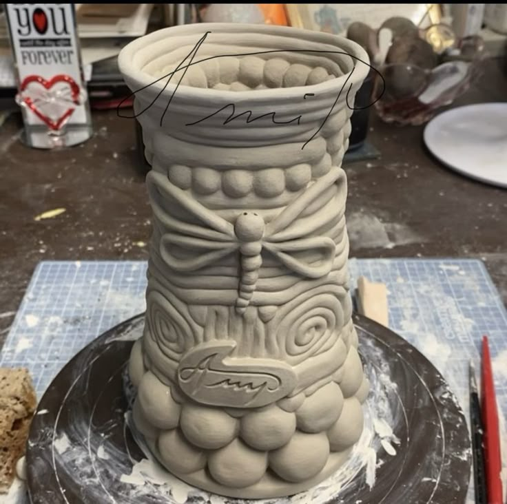 a large vase sitting on top of a table next to a knife and other items