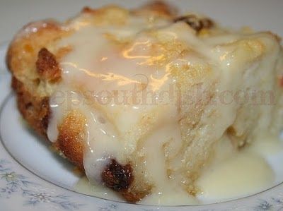 a close up of a piece of cake on a plate with icing and raisins