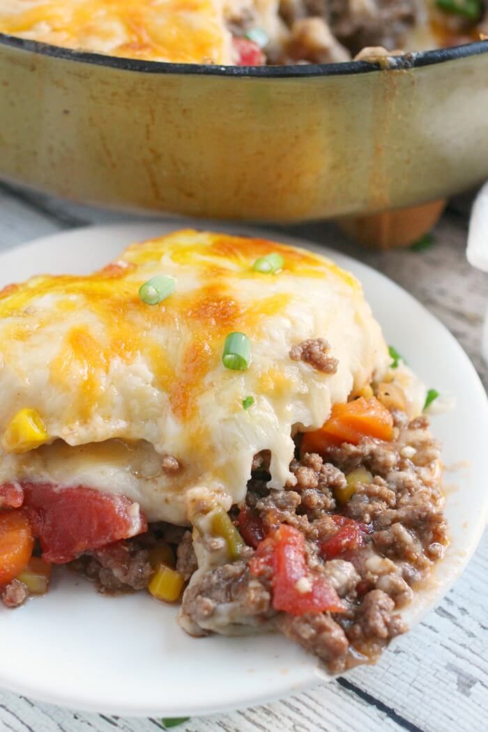 a close up of a plate of food with meat and vegetables on it next to a casserole dish