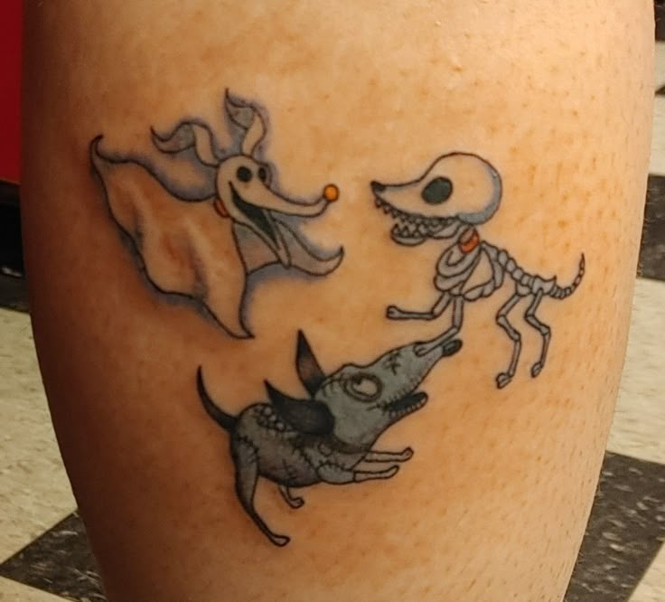 a tattoo on the leg of a person with an alien and dog design on it