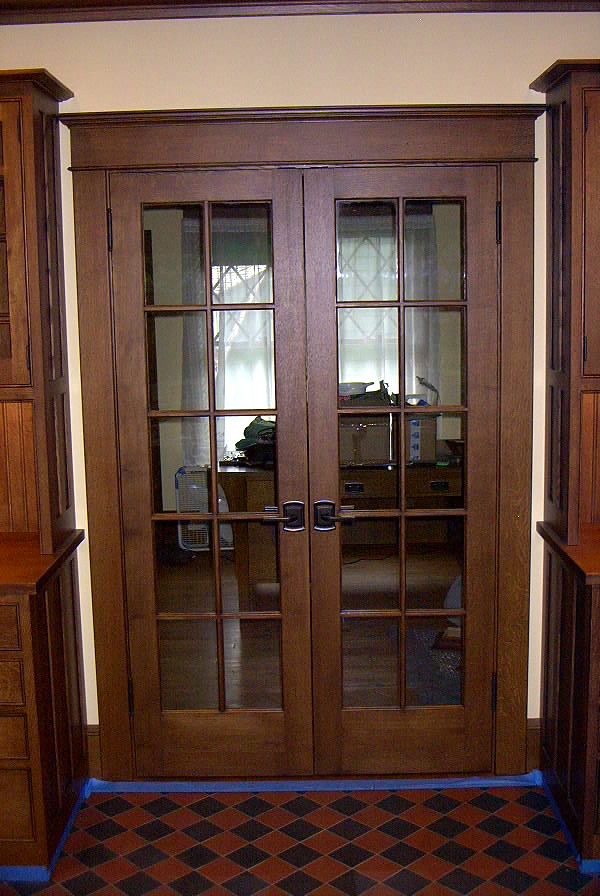 an empty room with wooden doors and checkered flooring on the carpeted floor