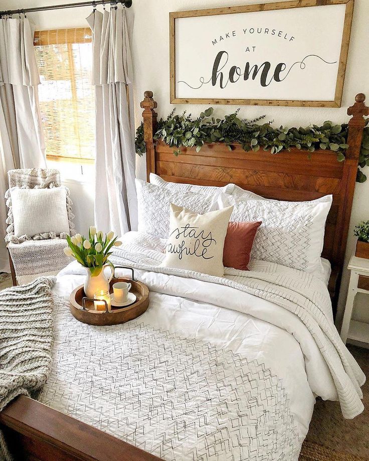 a bed with pillows and blankets on it in front of a sign that says home