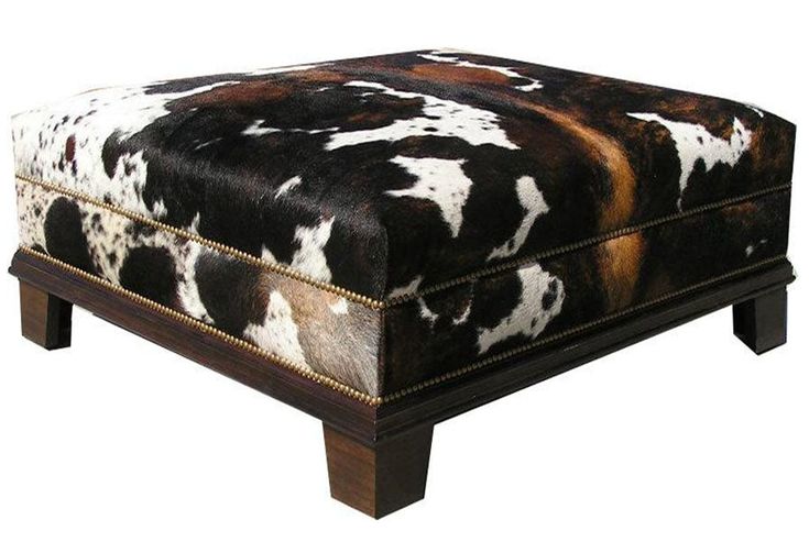 a brown and white cow print foot stool