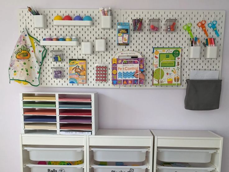 the wall is filled with craft supplies and storage bins for children's crafts