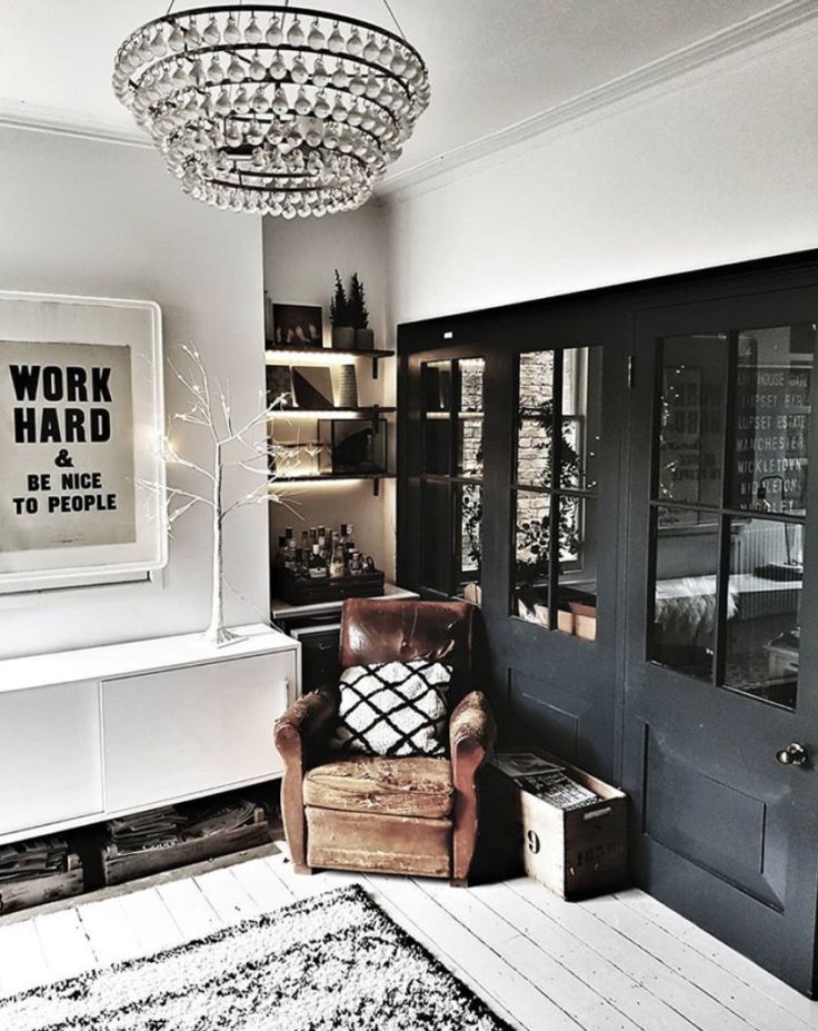 a living room filled with furniture and a chandelier hanging from the ceiling above it