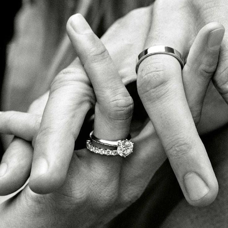 two people holding hands with wedding rings on their fingers