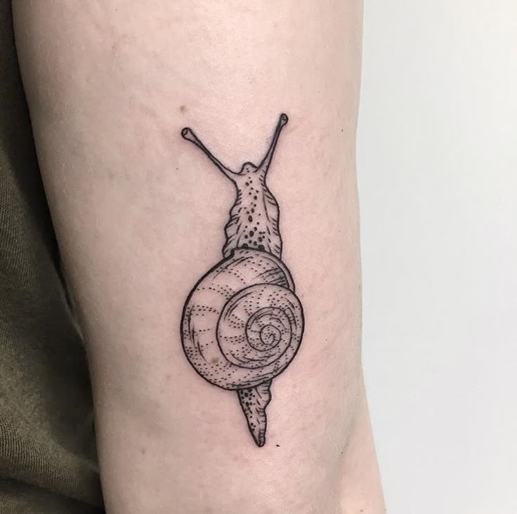 a small snail tattoo on the right thigh and lower leg, it is black and white