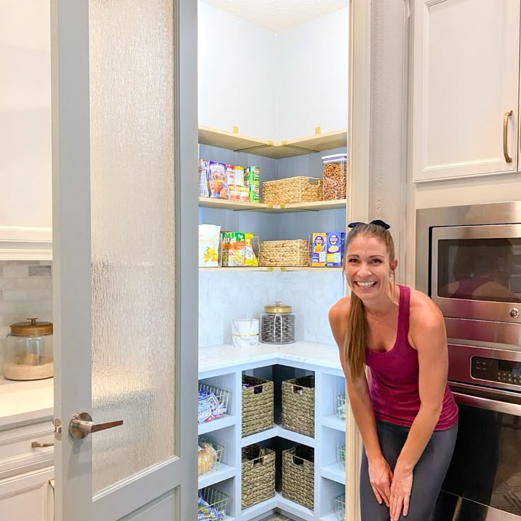 a woman is sitting in the corner of a kitchen