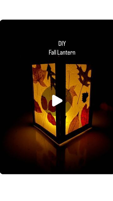 a lamp that has leaves on it and is lit up with the words diy fall lantern