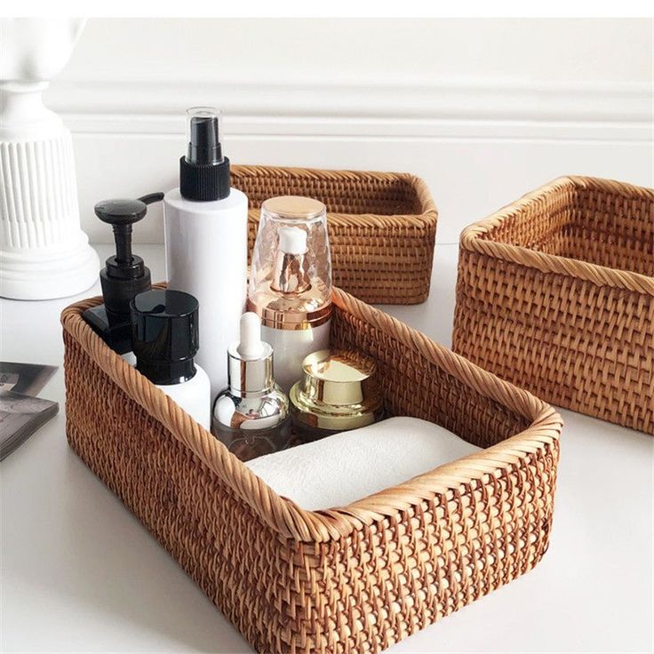 three wicker baskets with soap, lotion and other items in them on a table