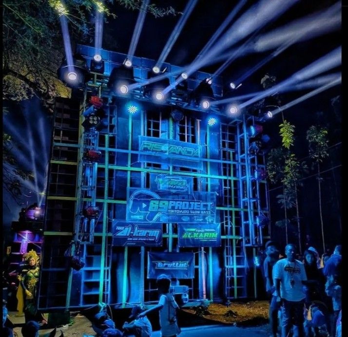 the stage is lit up with blue lights and people are standing around in front of it