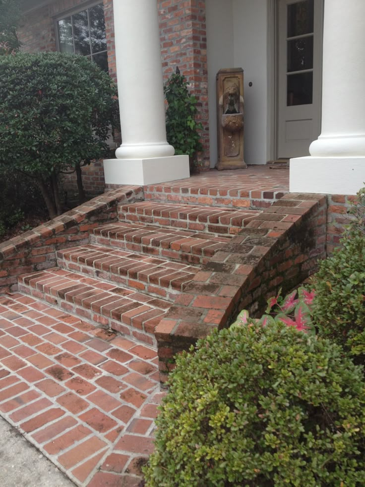 a brick porch with steps leading up to the front door