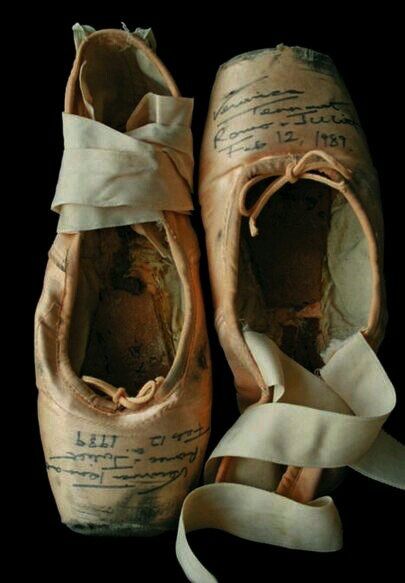 an old pair of ballet shoes with ribbons tied around them