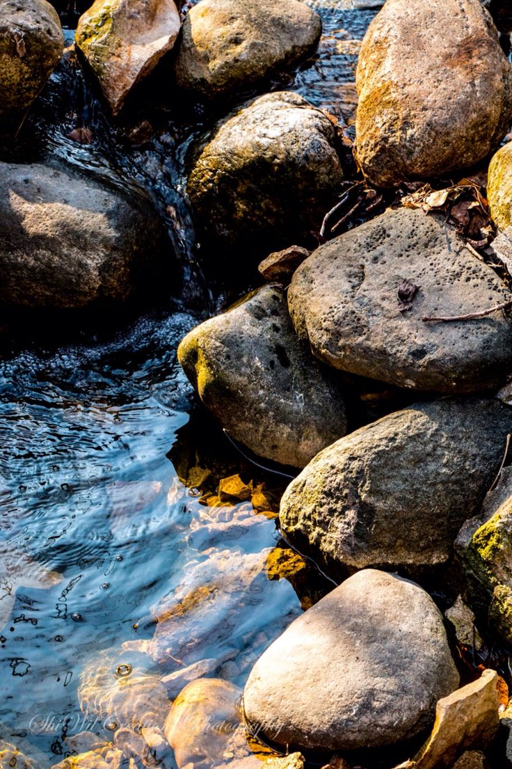 some rocks and water in the middle of a stream