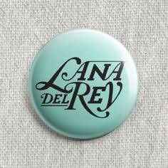 a button with the words cana del re in black ink on a light blue background