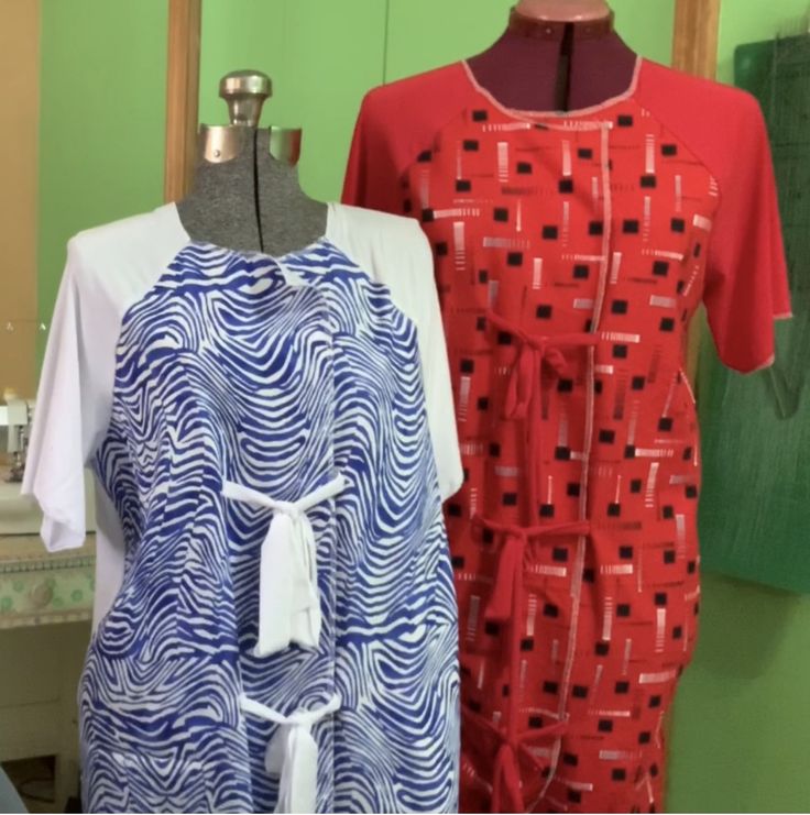 two dresses on mannequins in front of green wall