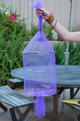 a person holding a purple object over a picnic table