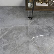 a bathroom with grey tile flooring and white fixtures on the sink counter top, along with an old fashioned faucet