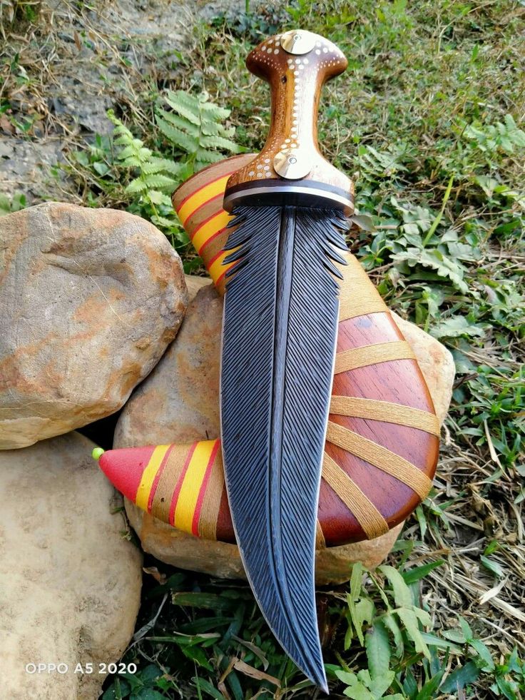 a decorative knife sitting on top of a rock