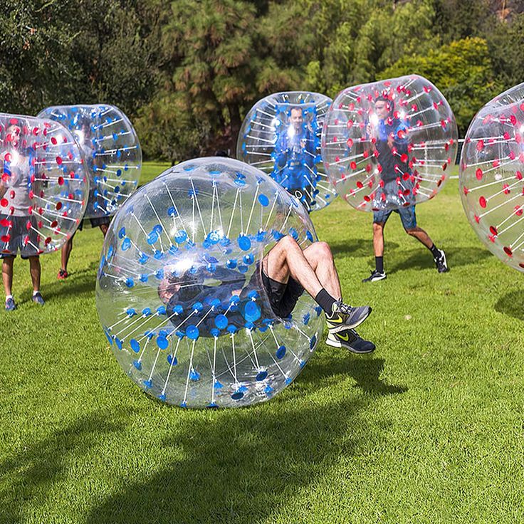 several people are playing in large balls on the grass