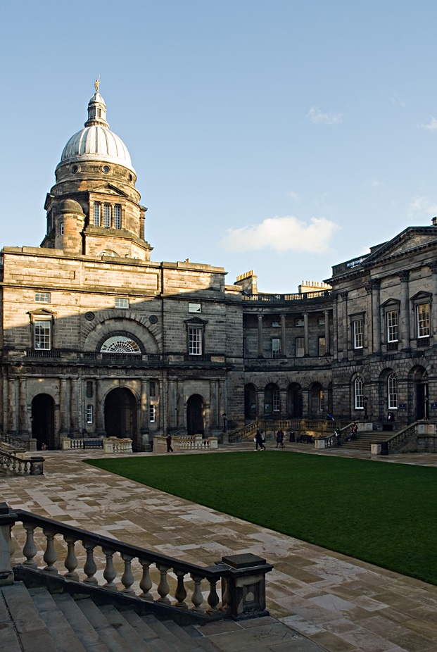 an old building with stairs leading to it and a clock tower in the back ground