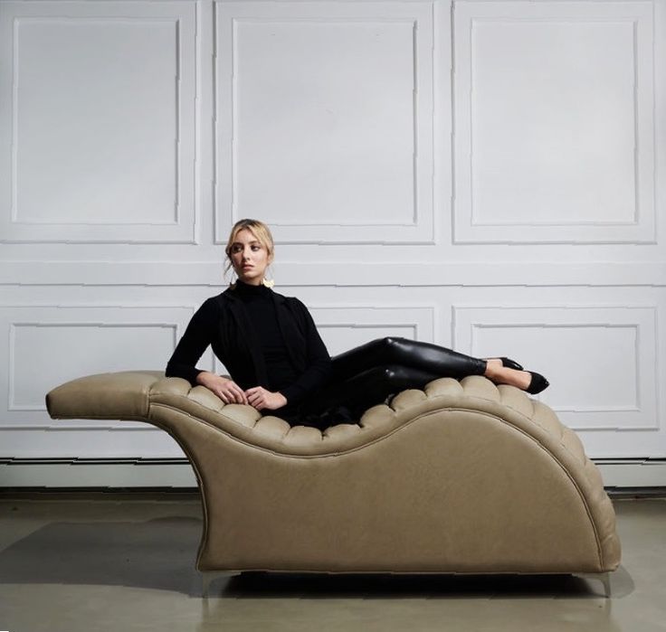 a woman sitting on top of a tan couch