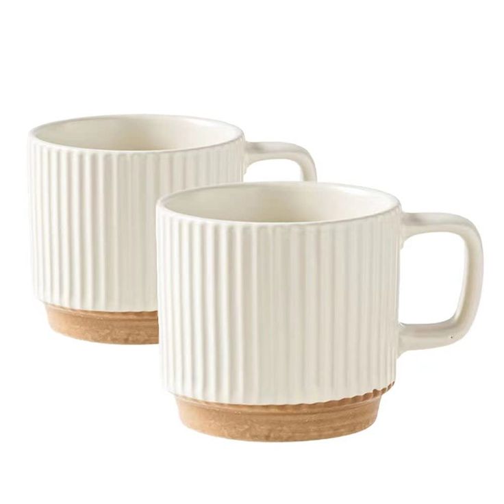 two white coffee mugs with wooden handles