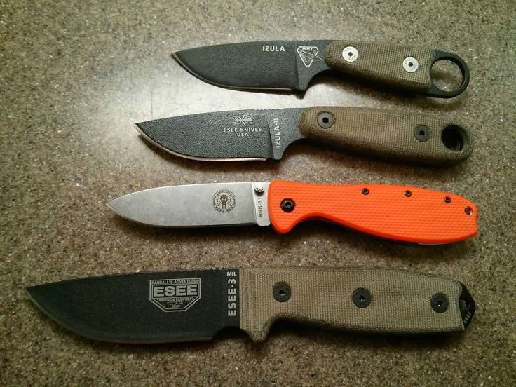 three knives are sitting next to each other on a counter top, one has an orange blade and the other is black