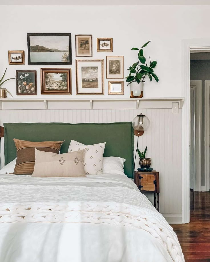 a bed with pillows and pictures on the wall above it