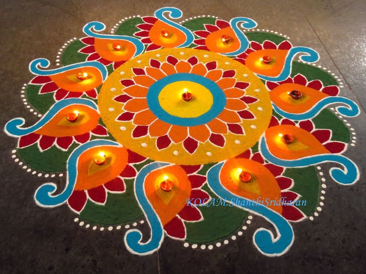 a colorful rangdi design with candles on the ground