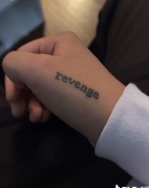 someone is holding their wrist with the word reverse written on it in cursive font