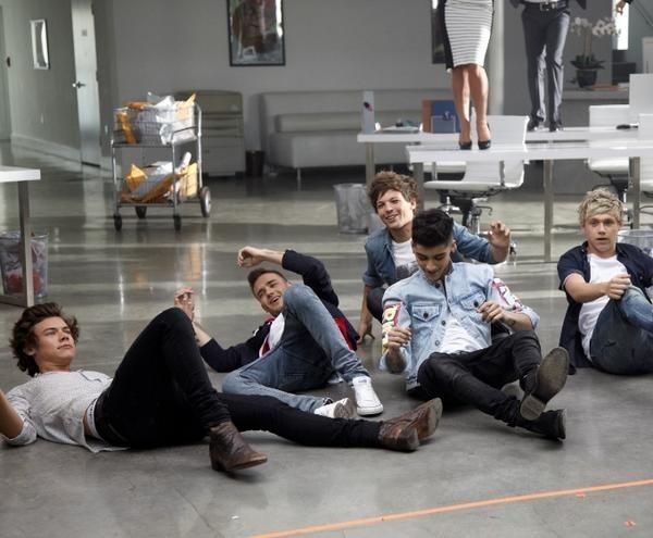 group of young men sitting on the floor in an office building