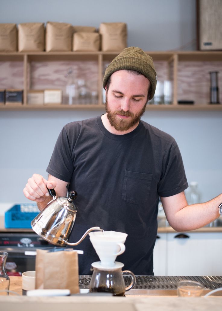 a man pours coffee into a cup