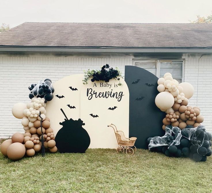 balloons and decorations are arranged in front of a house for a baby's first birthday