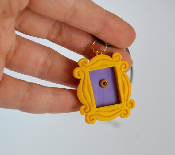 a hand holding a small yellow and purple frame