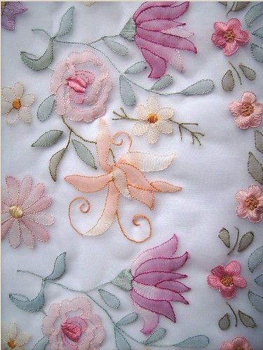 an embroidered fabric with flowers and leaves on it