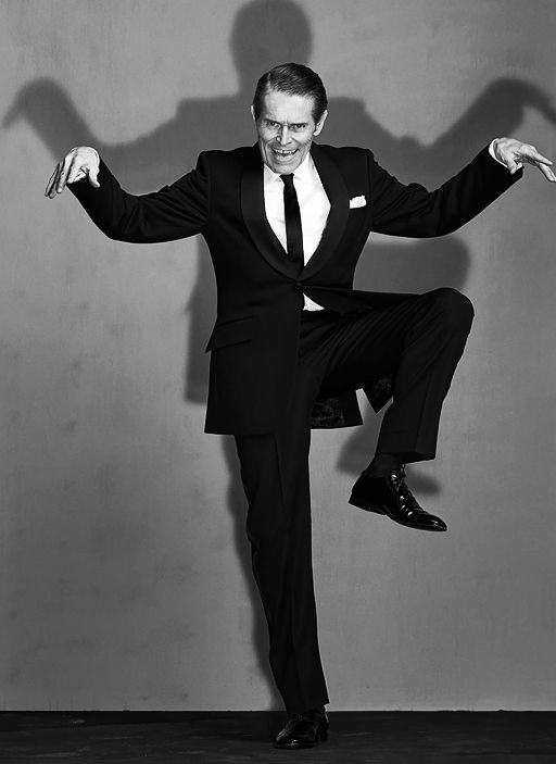 a man in a suit and tie jumping up into the air