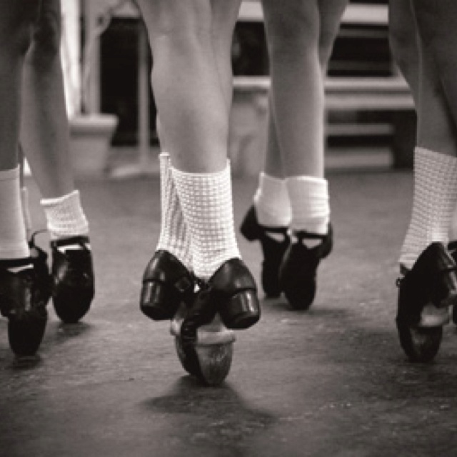 three women in short shorts and socks are riding roller skates