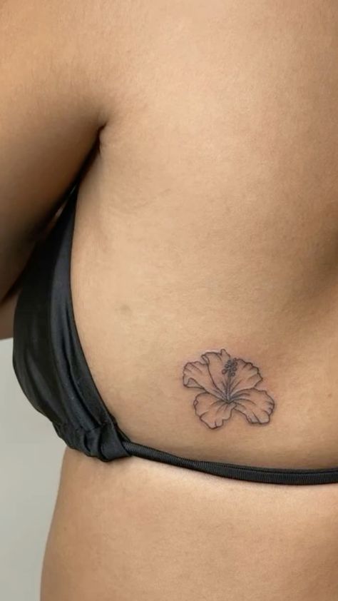 a woman's stomach with a flower tattoo on it