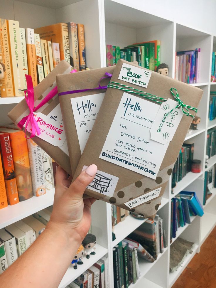 someone is holding up some books in front of a book shelf