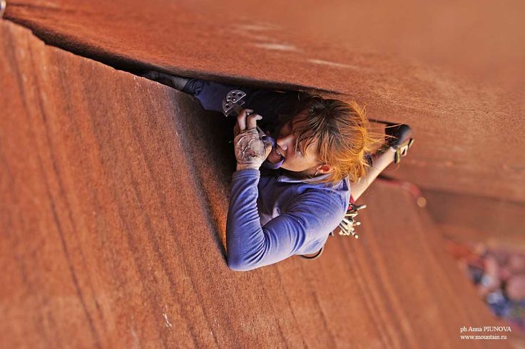 a woman leaning up against a wall talking on a cell phone