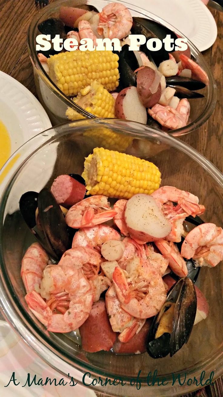 two bowls filled with shrimp, corn and mussels on top of a wooden table