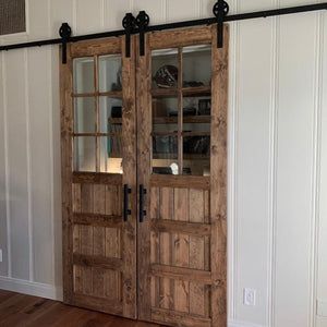 two wooden doors in a room with white walls and wood flooring on the side