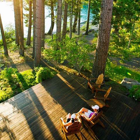 two wooden chairs sitting on top of a wooden deck